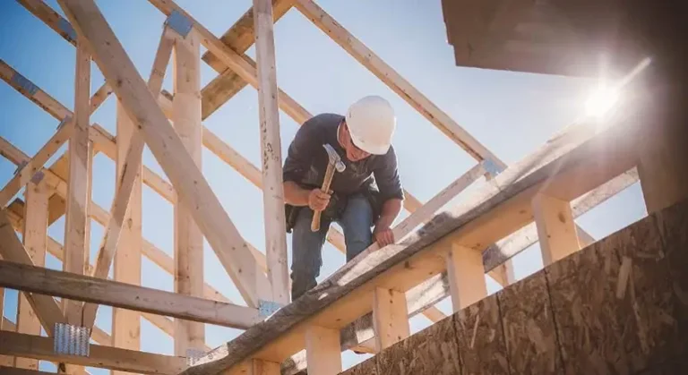 Charpentier travaillant sur une structure de maison en bois au Nouveau-Brunswick